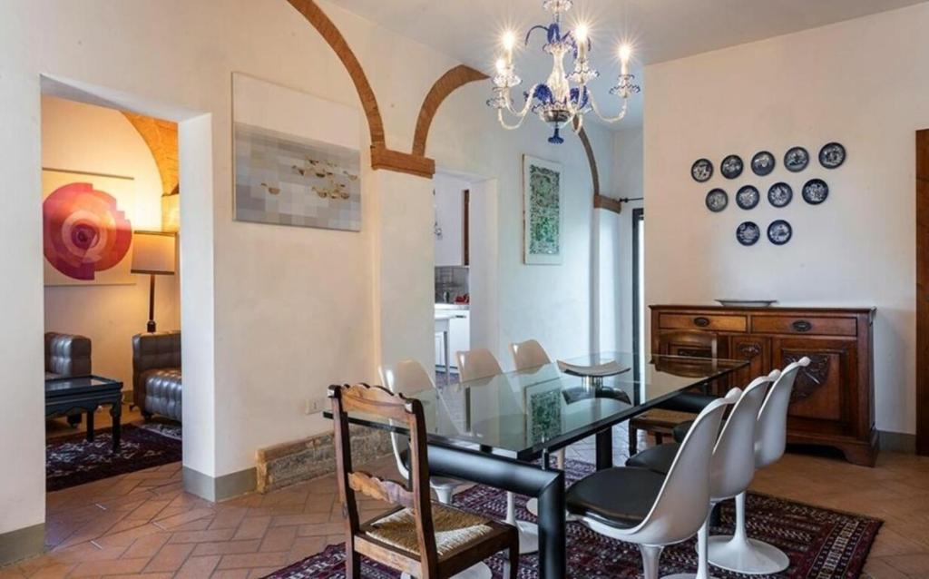 jadalnia ze szklanym stołem i krzesłami w obiekcie Villa le Mura w mieście Montaione