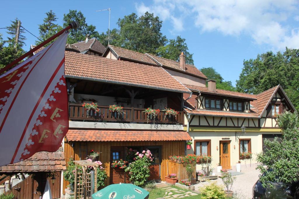 une maison avec balcon et drapeau dans l'établissement La Maison de Vacances, à Nothalten