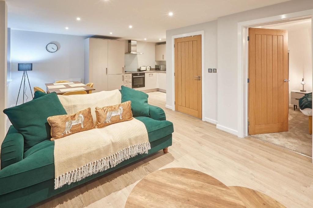 uma sala de estar com um sofá verde e uma cozinha em Host & Stay - Fern em York