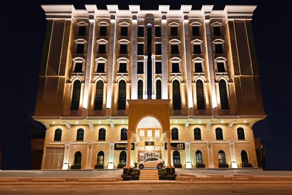 a large building with a car parked in front of it at Emerald Hotel in Jeddah
