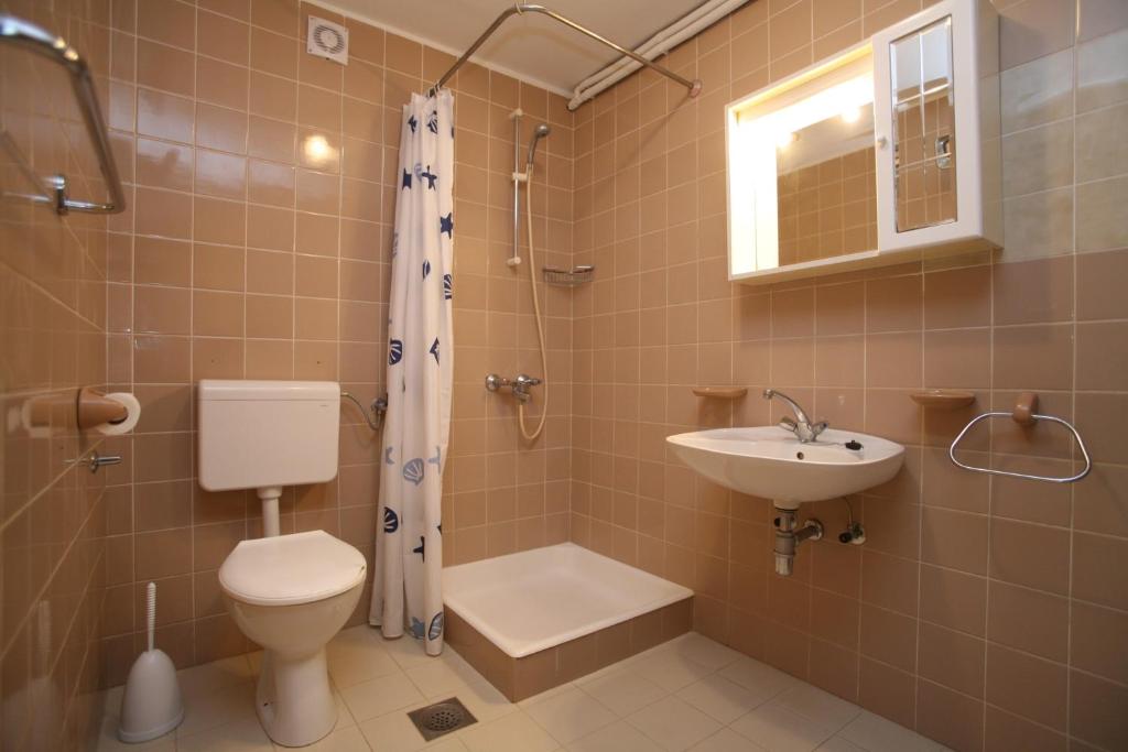 a bathroom with a toilet and a sink and a shower at Apartments Neda - Poreč South in Poreč