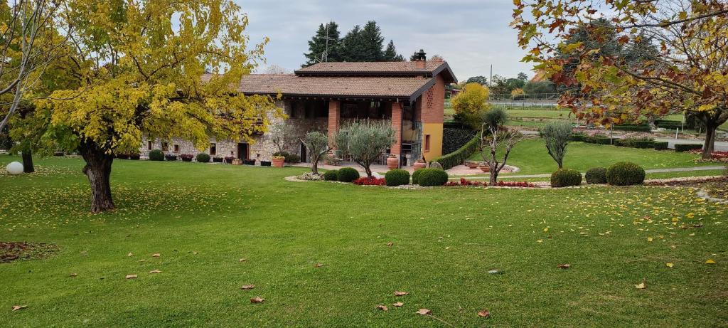 una casa en un patio con césped verde en Agriturismo Molino dei Frati, en Trescore Balneario