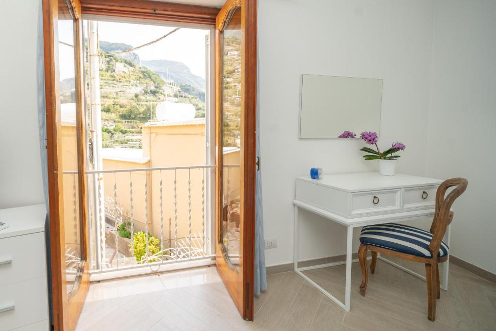 a desk and a chair in a room with a window at Villa Virginia in Positano