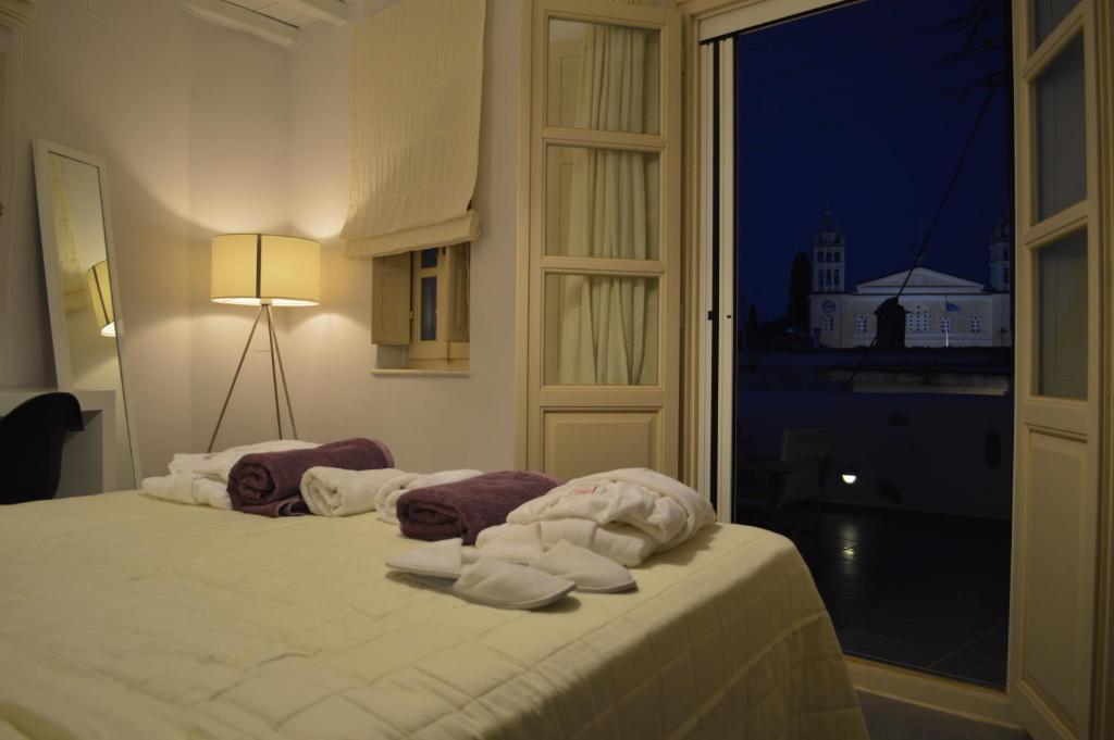 a bed with towels on it in a room with a window at Villa Byzantino in Lefkes