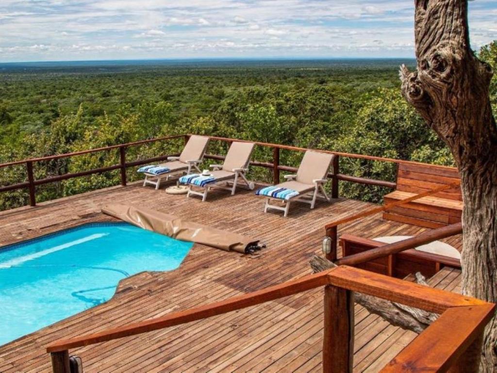 a deck with chairs and a pool on top of a tree at Eclectic Safari Lodge in Mabula