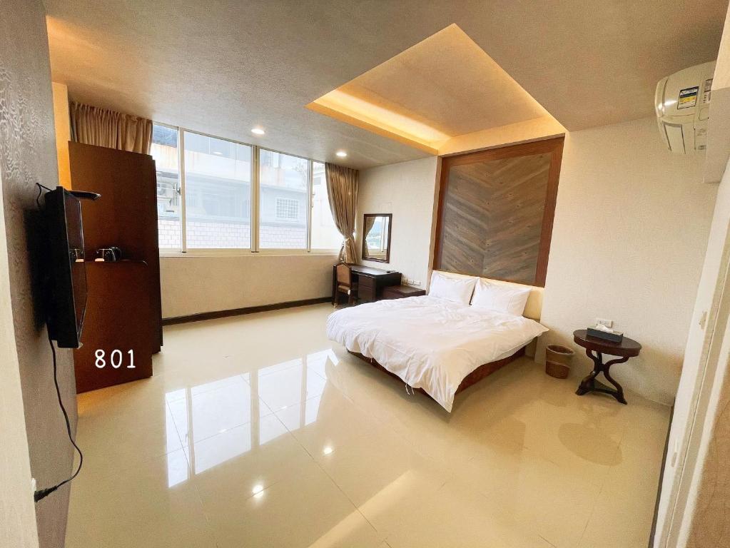 1 dormitorio con 1 cama y TV. en 花蓮花見你民宿 en Hualien
