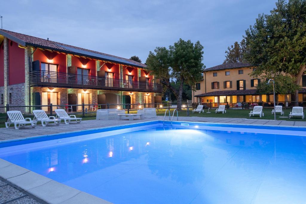 una grande piscina di fronte a un edificio di Agriturismo ai Due Leoni a Aquiléia