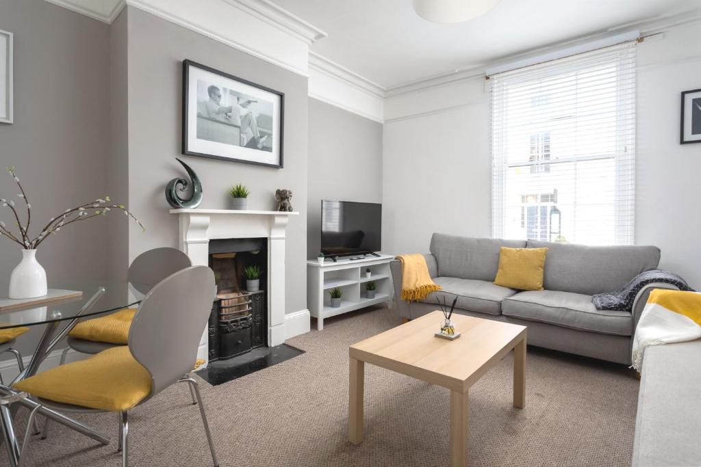 a living room with a couch and a table at St George's Place - Fab Cheltenham Town House in Cheltenham