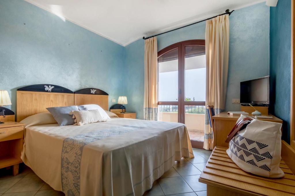 a bedroom with a bed and a large window at Hotel Villa del Mare Solanas in Solanas