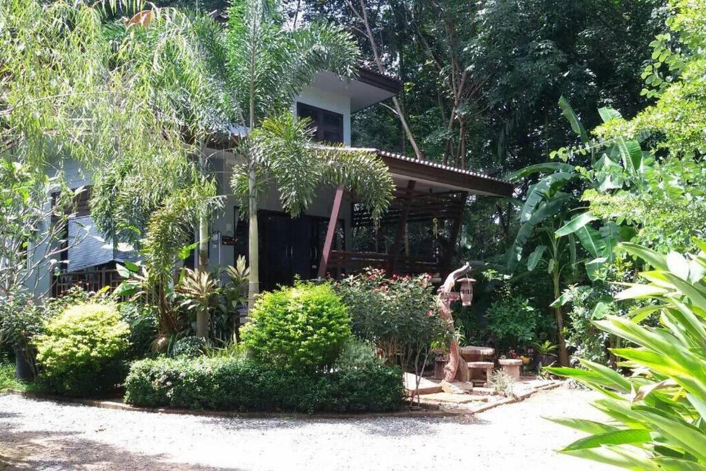 ein Haus mit vielen Pflanzen davor in der Unterkunft Rose-Bud Cottage in Ko Chang