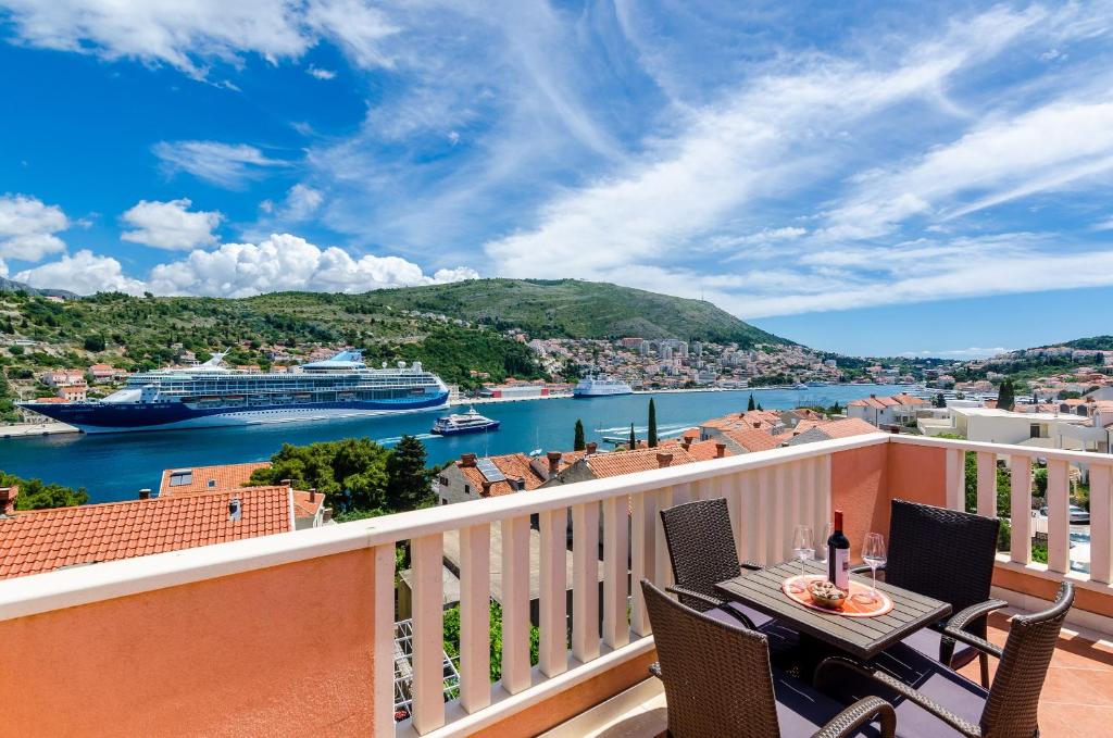a balcony with a table and chairs and a view of a harbor at Guest House Avdic in Dubrovnik