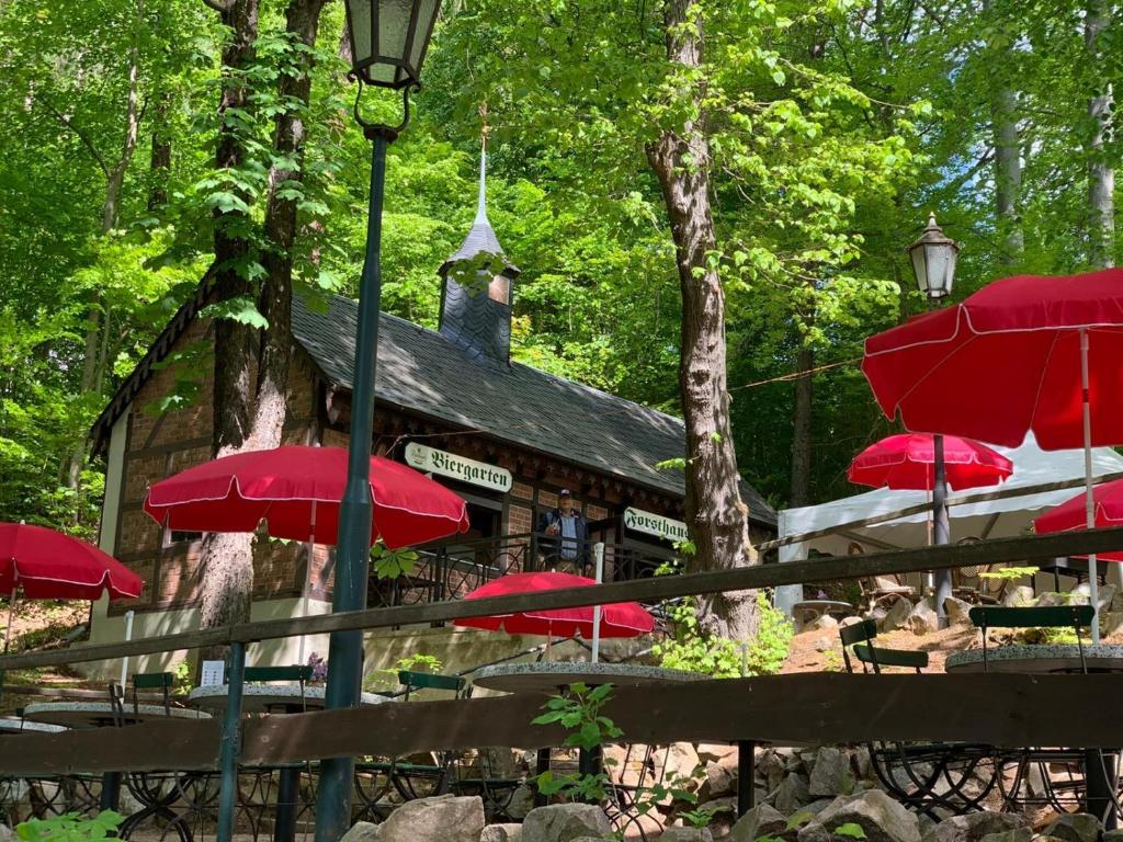 a group of red umbrellas in front of a building at Forsthaus in Crimmitschau