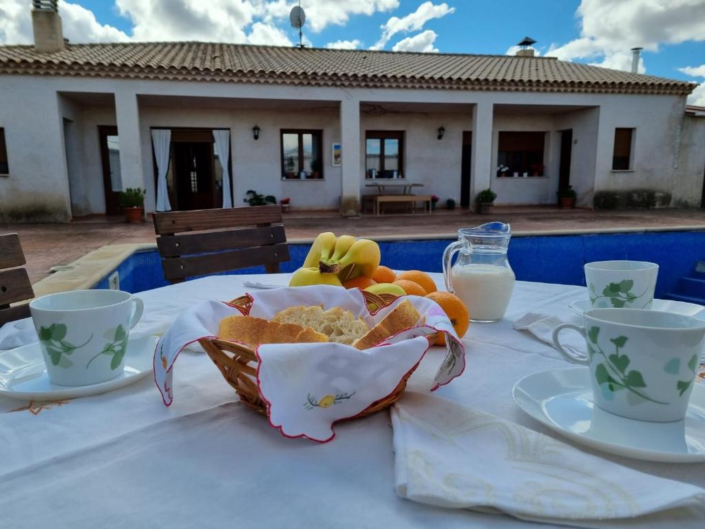 una mesa con un tazón de comida y dos tazas de leche en Casa Rural El Duende, en Monreal del Llano