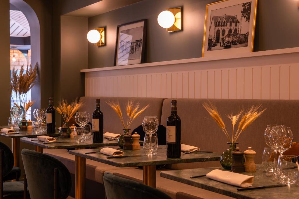 a row of tables in a restaurant with wine bottles at Le Celtique & Spa in Carnac