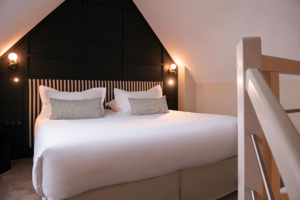 a bedroom with a large white bed with two pillows at Le Celtique & Spa in Carnac