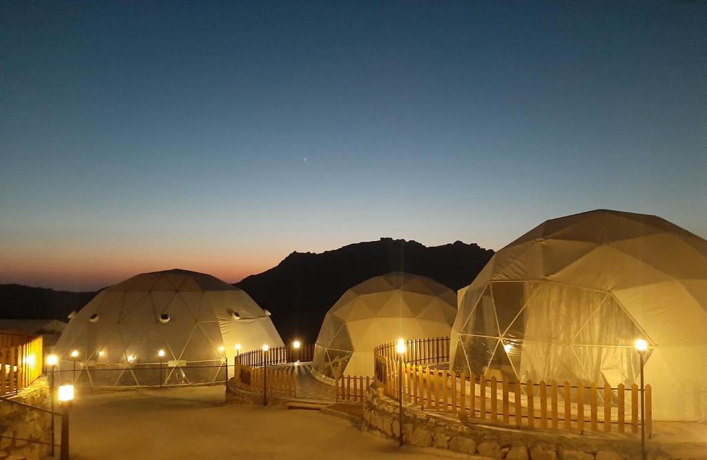 um grupo de cúpulas no deserto à noite em The Rock Camp Petra em Wadi Musa