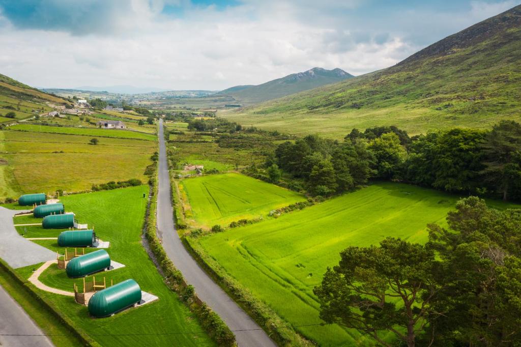 an aerial view of a farm with green fields and mountains at Further Space at Leitrim Lodge Luxury Glamping Pods Mourne Mountains in Newcastle