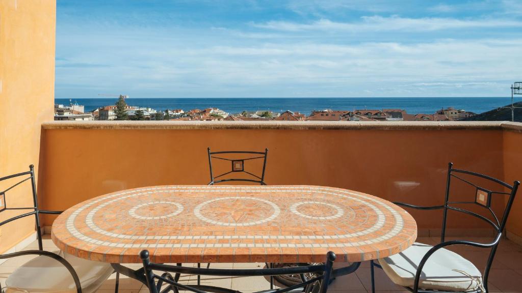 a table on a balcony with a view of the ocean at Virgilio 2 - Villa Bice in Alassio