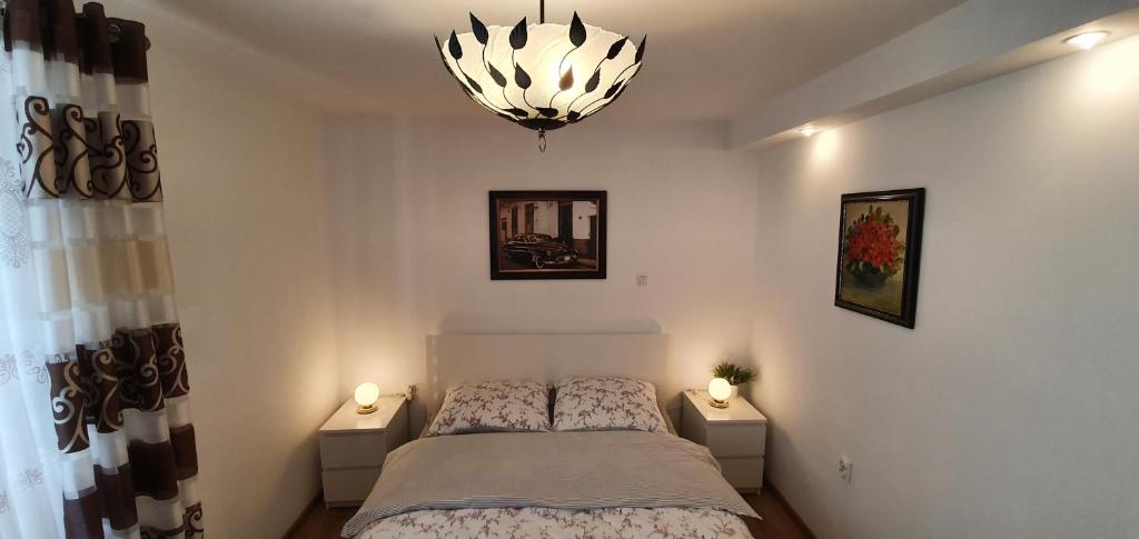 1 dormitorio con cama y lámpara de araña en Apartament Kaduk, en Nowy Sącz
