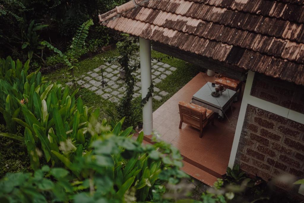 vistas a un patio con mesa y banco en Villa Akasa, en Varkala