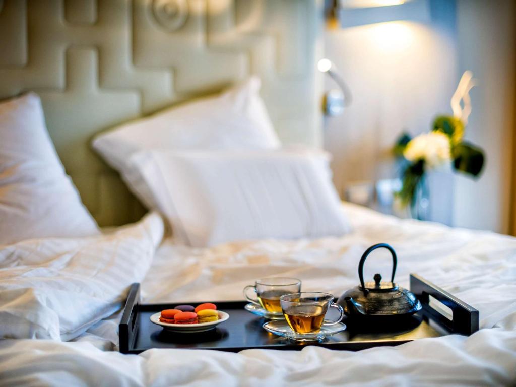 a tray of food and drinks on a bed at Almar Timi Ama Resort & Spa in Villasimius