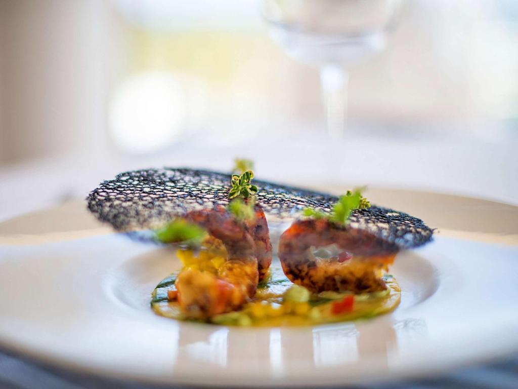 a plate with some food on a table at Almar Timi Ama Resort & Spa in Villasimius