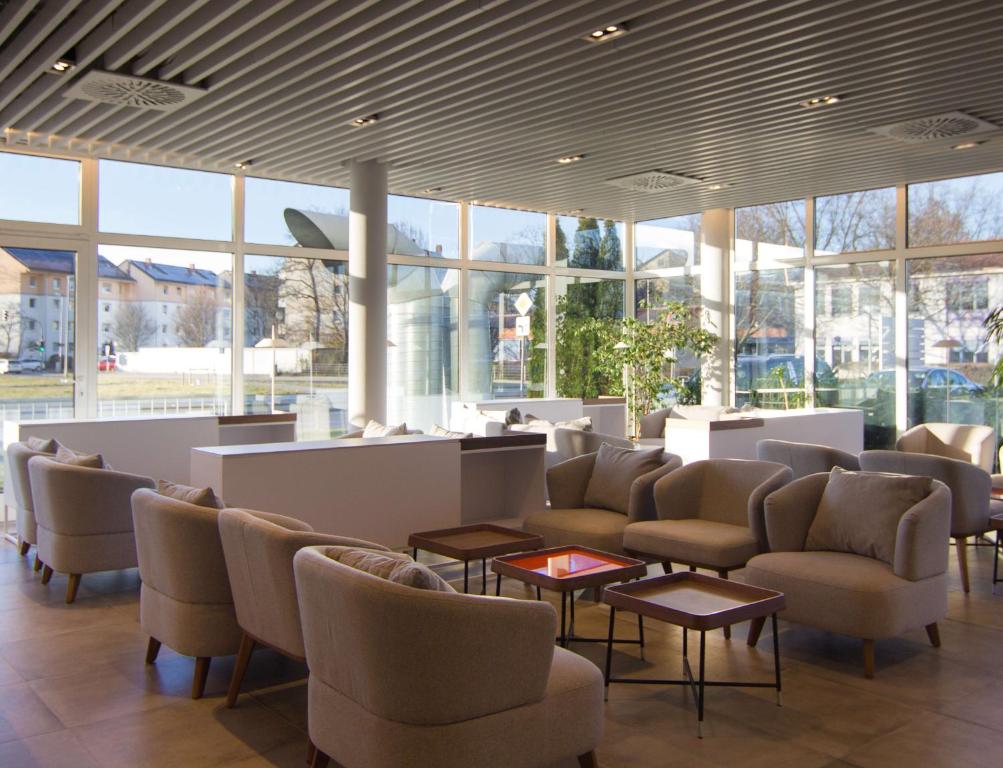 a waiting room with chairs and tables and windows at Best Western soibelmanns Frankfurt Airport in Groß-Gerau