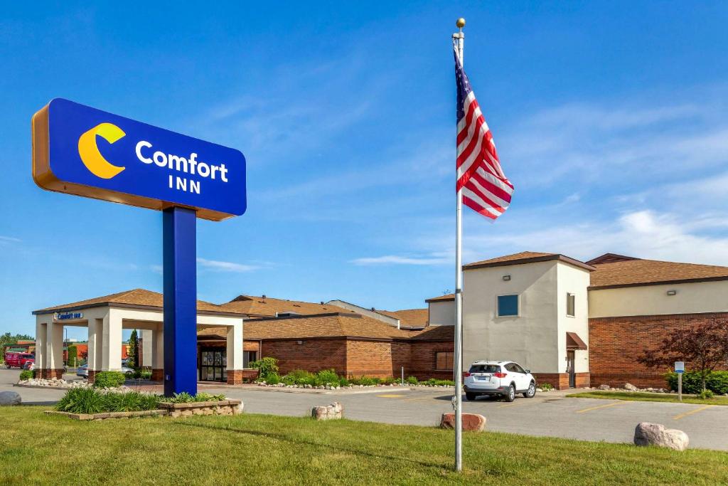a sign for a comfort inn with an american flag at Comfort Inn in Sault Ste. Marie