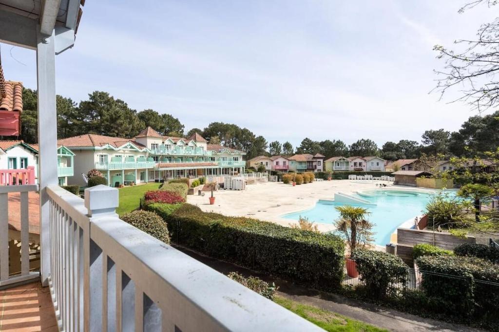 uitzicht op een zwembad vanaf een balkon van een huis bij Maison sur golf avec piscine chauffée à Lacanau Océan in Lacanau