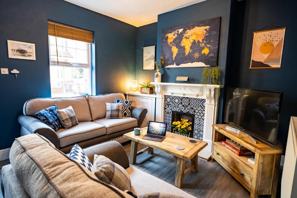 a living room with a couch and a fireplace at Sunrise Beach House in Cleethorpes