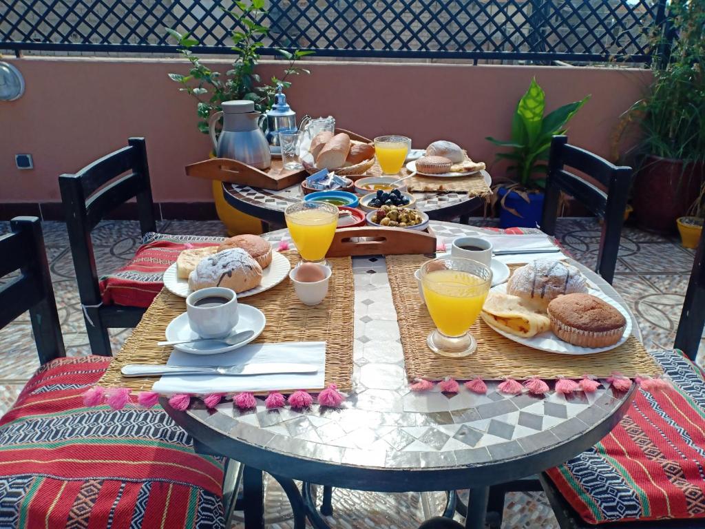 a table with breakfast foods and orange juice on it at Dar HAJAR in Marrakech