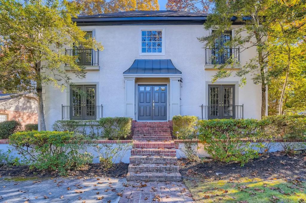 una casa blanca con una puerta azul y escaleras en Edgewater Estate - 5 Bdrm Sleeps 10 - Near It All en Atlanta