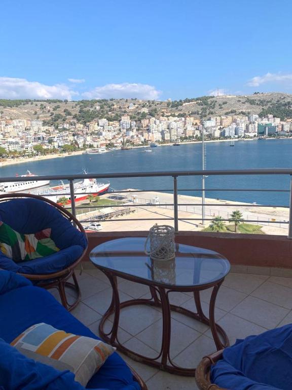 a balcony with a table and chairs and a view of the water at Saranda Port View Apartments in Sarandë