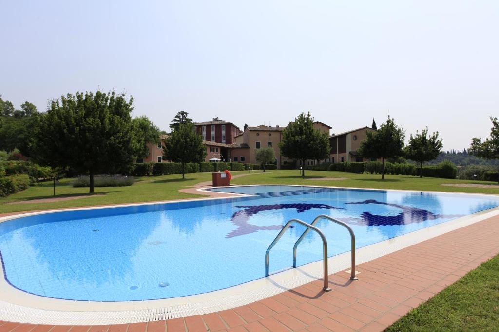 a large blue swimming pool in a yard at Appartamenti I Cortivi in Costermano