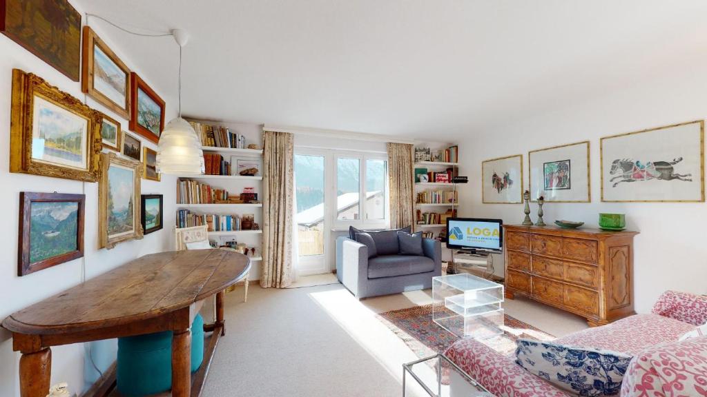 uma sala de estar com uma mesa e um sofá em Plattas 9 em St. Moritz