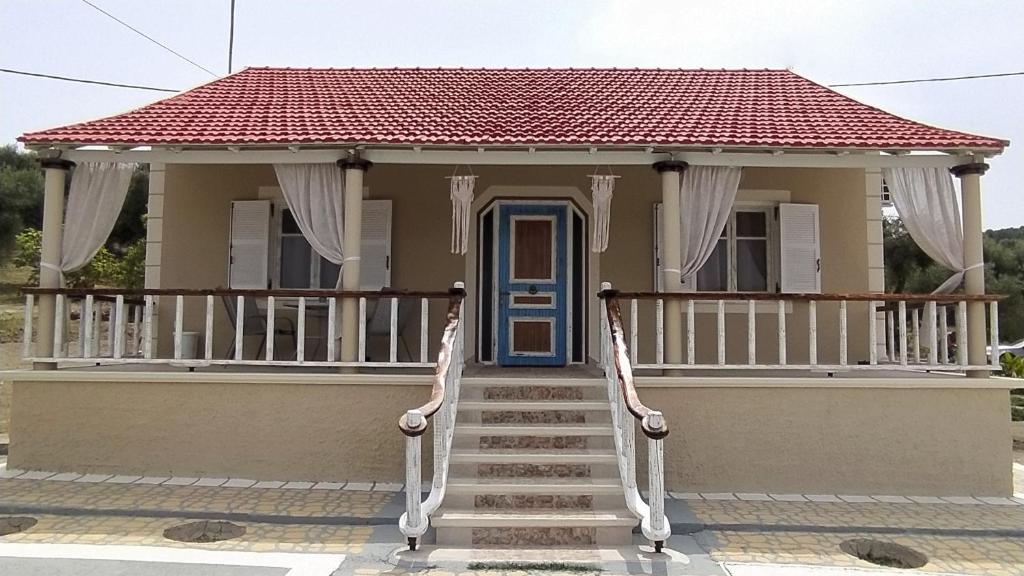 une petite maison avec une porte bleue et des escaliers dans l'établissement Villa Christa, à Arillas