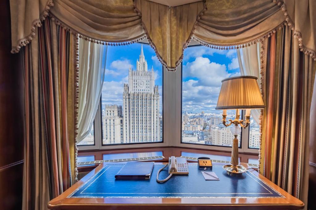 a desk in front of a window with a view of the city at Golden Ring Hotel in Moscow