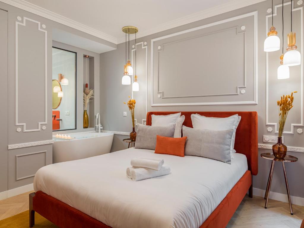 une chambre avec un grand lit et une salle de bain dans l'établissement The Orange Haussmann, à Paris