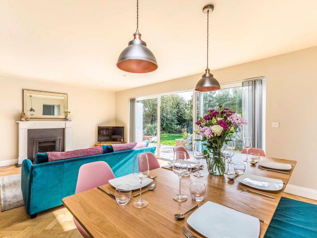 a dining room with a table and a blue couch at Pass the Keys Stylish and fresh 4 bed beach house with garden in Chichester