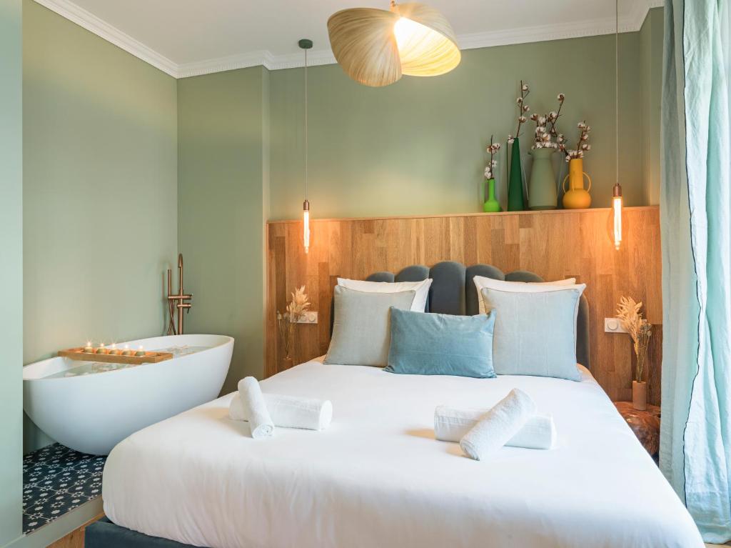 ein Schlafzimmer mit einem großen Bett und einer Badewanne in der Unterkunft Nature and Haven of Peace Apartment in Paris