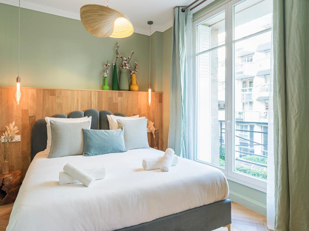 a bedroom with a large bed with a large window at Nature and Haven of Peace Apartment in Paris