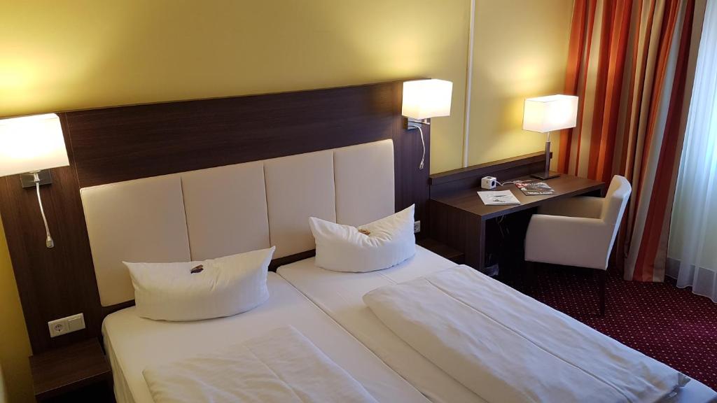 Postel nebo postele na pokoji v ubytování INVITE Hotel Nürnberg City