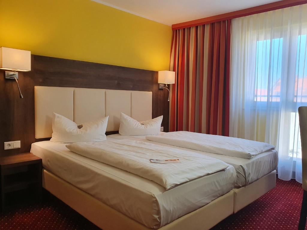 Postel nebo postele na pokoji v ubytování INVITE Hotel Nürnberg City