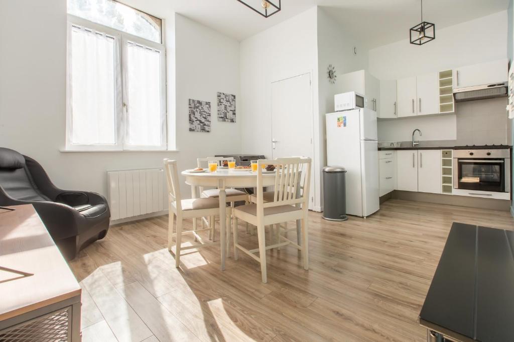 - une cuisine et une salle à manger avec une table et des chaises dans l'établissement Appartement moderne, propre, WIFI, siège massant, à Roncq