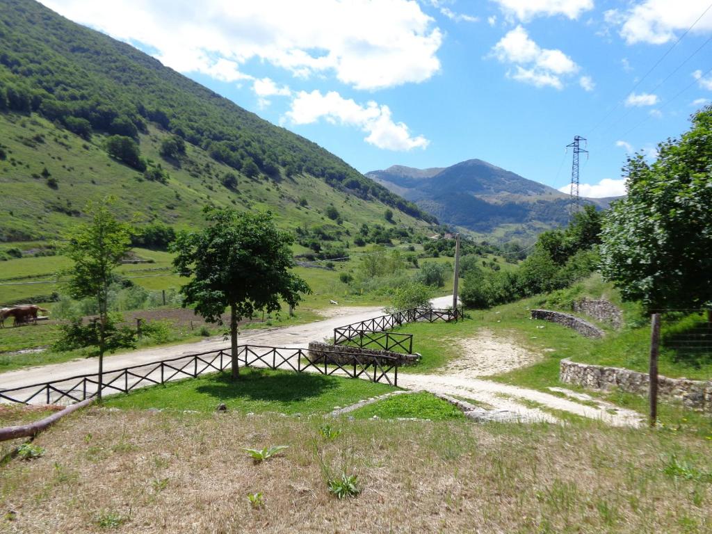 eine Gruppe von Bänken auf einer unbefestigten Straße mit Bergen in der Unterkunft Agriturismo Le Prata in Scanno