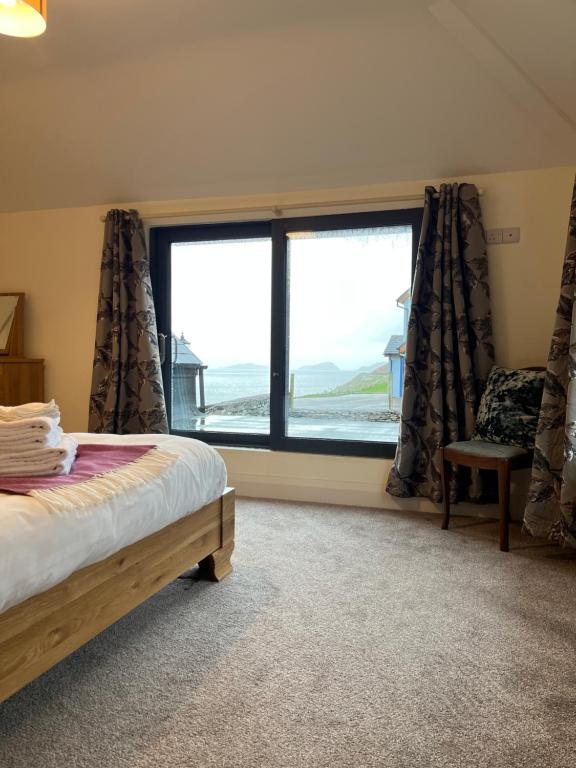 a bedroom with a bed and a large window at Old Irish farmhouse in Dingle