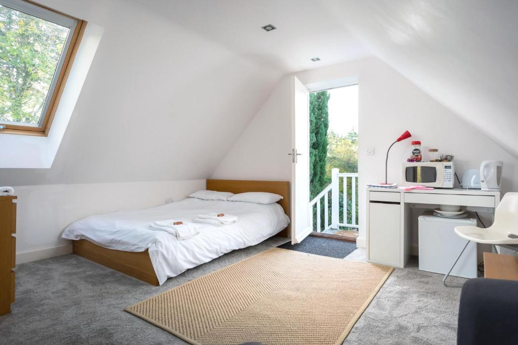 een slaapkamer met een bed en een bureau met een magnetron bij The Annexe in Cheltenham