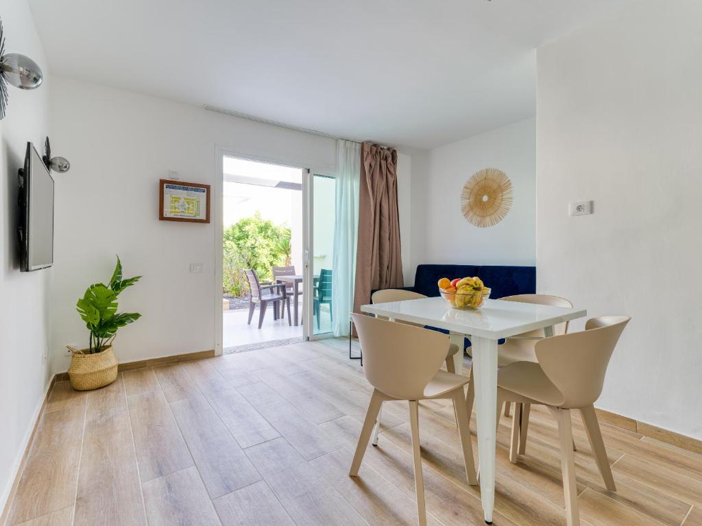 comedor con mesa blanca y sillas en HomeForGuest Moderno Apartamento con piscina en Corralejo, en Corralejo