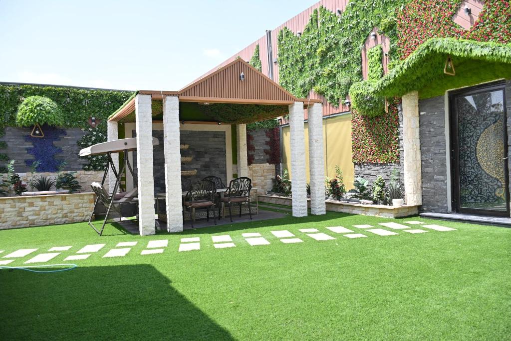 un jardín con un patio con césped en SHALLY VILLAGE en Dammam