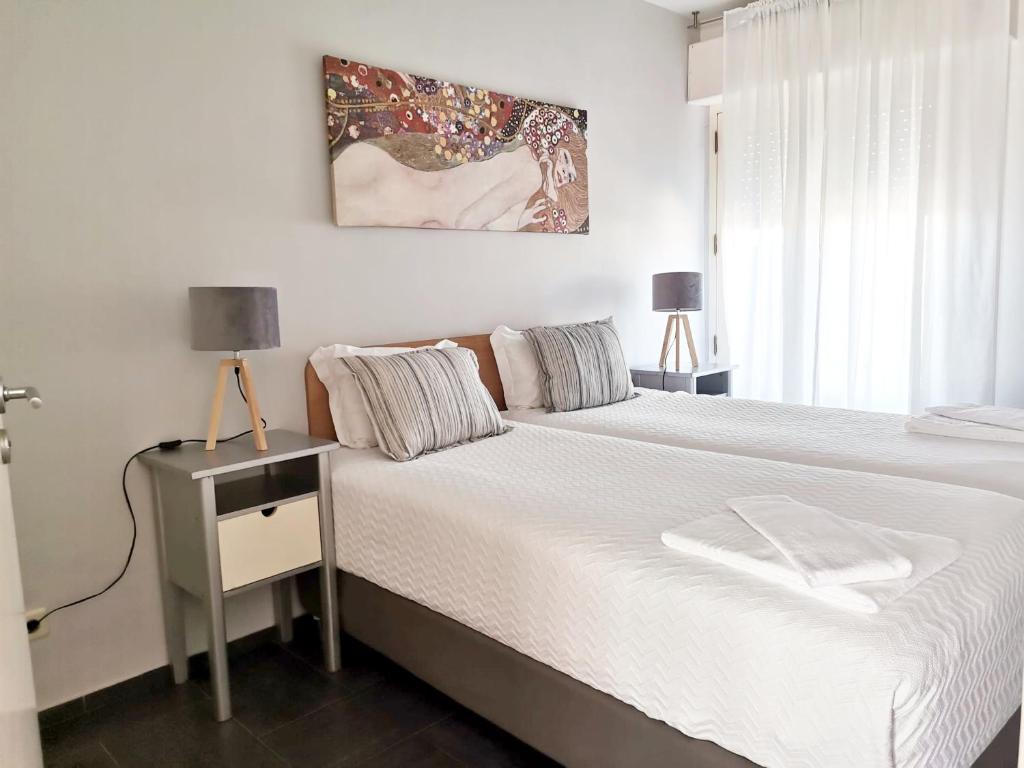 a bedroom with a white bed and a window at Unique Apartment Milfontes - Duna Parque Resorts & Hotels in Vila Nova de Milfontes
